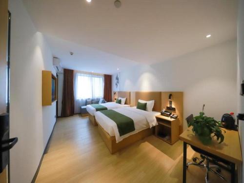 a large hotel room with a bed and a desk at Green Tree Inn Guangxi Wuzhou 2nd Xinxing Road Liangguang Market in Wuzhou