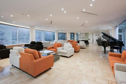 uma sala de estar com sofás e um piano de cauda em Hotel West of Canaan (Korea Quality) em Sangch'o