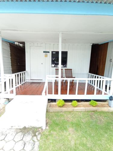 a porch of a white house with a table at Hello Bintan in Kangkakawal