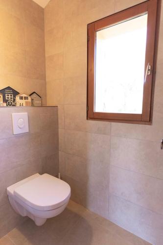 a bathroom with a toilet and a window at Residence Mare e Sole in Taglio-Isolaccio