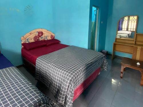 a bedroom with a bed and a table and a mirror at Good Karma Bromo Guesthouse in Bromo