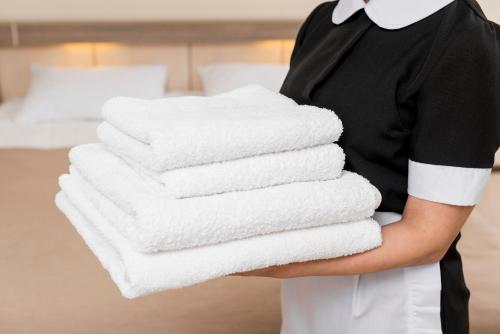 uma pessoa segurando uma pilha de toalhas em um quarto de hotel em Brand new 1 bedroom in Le Suquet em Cannes