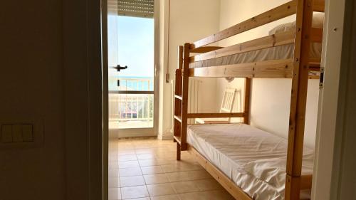 a bedroom with two bunk beds and a balcony at Trilocale centro Marcelli fronte mare - M223 in Marcelli