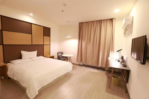سرير أو أسرّة في غرفة في Hanting Hotel Harbin Xidazhi Street Gongda