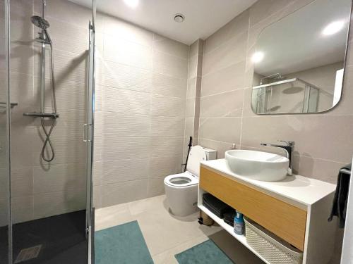 a bathroom with a toilet and a sink and a shower at Kololi Sands Apartments in Sere Kunda