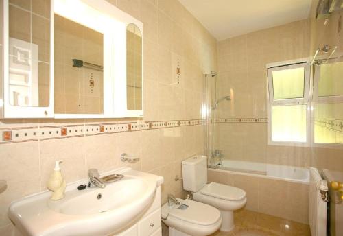a white bathroom with a sink and a toilet at Beautiful Villa La Caracola in Marbella