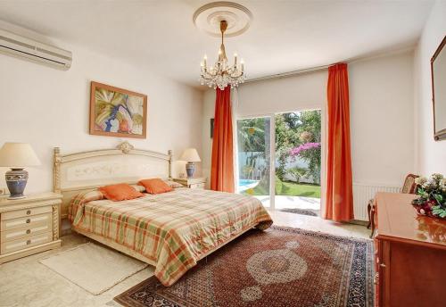 a bedroom with a bed and a chandelier at Beautiful Villa La Caracola in Marbella