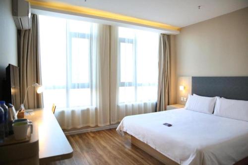 Hanting Hotel Changchun Gaoxin Distract Guanggu Street tesisinde bir odada yatak veya yataklar