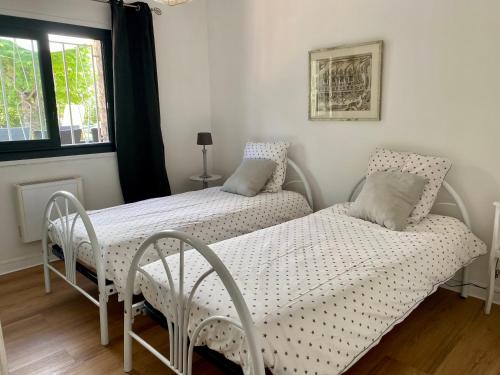 two twin beds in a room with a window at Villa Côte d'Azur piscine privée in La Gaude