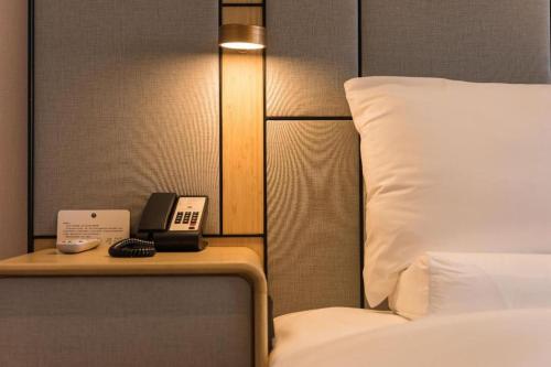 a hotel room with a bed and a phone on a table at Ji Hotel- Putian Phoenix Mountain Park in Putian