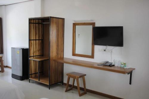 escritorio con TV y espejo en la pared en S Residence (S HOTEL), en Ban Nong Pla Kho