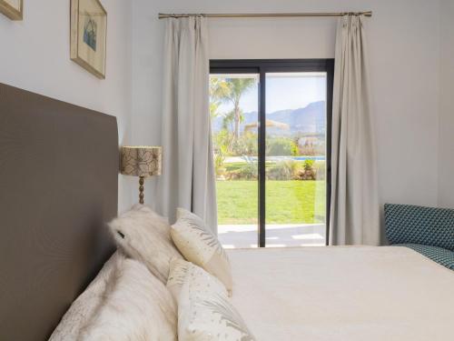 a bedroom with a bed with a view of a window at Cubo's Casa Rural El Oasis De Don Pedro in Villafranco de Guadalhorce