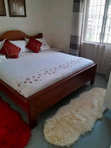 un letto con cuscini rossi sopra in una camera da letto di Mone Airbnb a Nambale