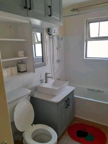 a bathroom with a white toilet and a sink at Mone Airbnb in Nambale