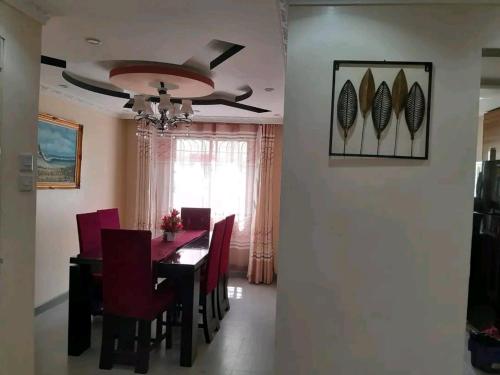 a dining room with a table and red chairs at Mone Airbnb in Nambale