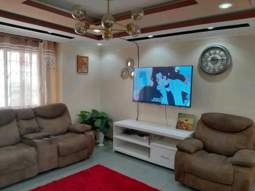 un soggiorno con 2 divani e una TV a schermo piatto di Mone Airbnb a Nambale