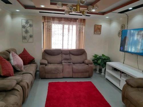un soggiorno con divano e TV a schermo piatto di Mone Airbnb a Nambale