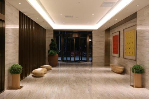 a lobby with benches and plants in a building at Ji Hotel Yinchuan Guangyao Center in Yinchuan