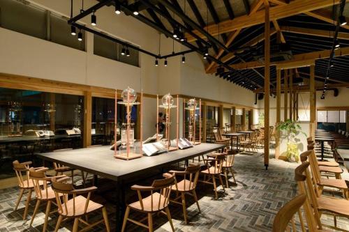 Ise Shinsen في Funaechō: غرفة طعام كبيرة مع طاولة وكراسي طويلة