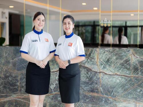 zwei Frauen stehen vor einer Marmortheke in der Unterkunft B2 Huai Khwang Premier Hotel in Ban Na Song