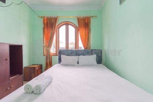 a bedroom with a bed with two towels on it at Villa Sari Intan Ciater RedPartner in Subang