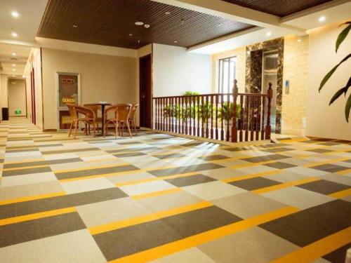 a lobby with a checkered floor with a table and chairs at Shell Hotel Xuzhou New Xinzhongwu Road in Donghecun