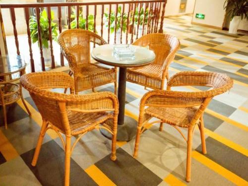 DonghecunにあるShell Hotel Xuzhou New Xinzhongwu Roadの籐の椅子とテーブル、テーブルと椅子