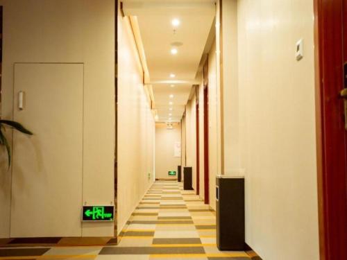DonghecunにあるShell Hotel Xuzhou New Xinzhongwu Roadの緑の出口標識のあるオフィスビルの廊下