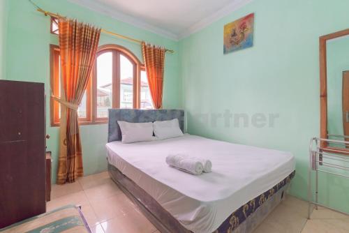 蘇邦的住宿－Villa Sari Intan Ciater RedPartner，窗户客房内的一张床位