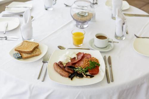 纽基The Beach House & Porth Sands Apartments的一张白色桌子,上面有盘子的食物