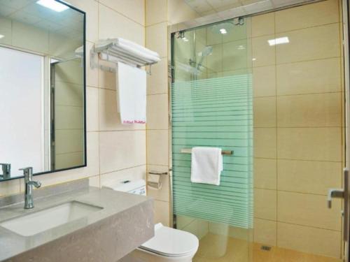 y baño con lavabo, aseo y ducha. en Shell Hotel Wuhu Jiujiang District Daqiao Town Huashan Road en Wanli