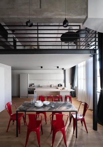 a dining room with a table and red chairs at EDIT Lofts in Turin