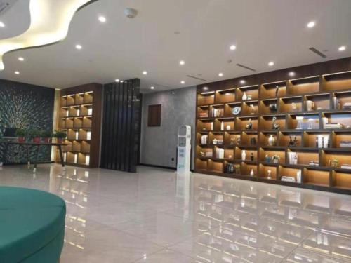 um átrio com uma parede de prateleiras com vasos em GEM Hotel Zibo Economic Development Zone Zibo Vocational Institute em Jinan