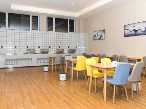 een restaurant met tafels en stoelen en een keuken bij GreenTree Inn Hubei Yangxin County Lianhua Lake Mingyue Bay in Yangxin