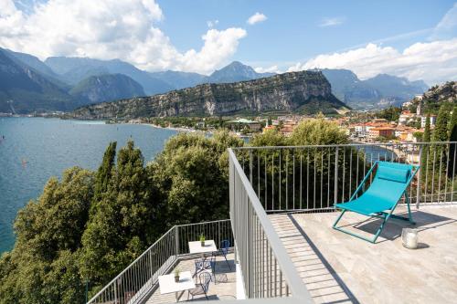 a blue chair sitting on a balcony overlooking a lake at VistaLago Torbole in Nago-Torbole