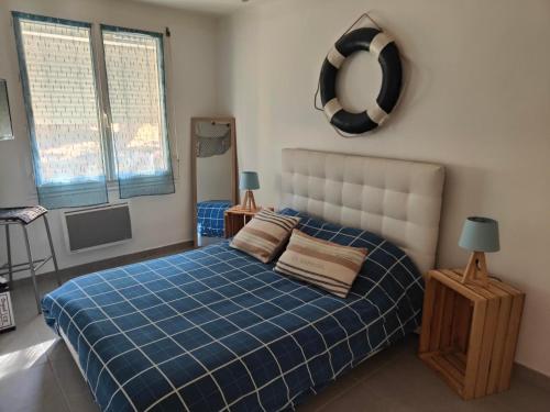 - une chambre avec un lit doté d'une couverture bleue et d'un miroir dans l'établissement Appartement SÈTE LA CORNICHE - 4 PERSONNES, à Sète