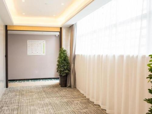 a hallway with a curtain and a plant at GreenTree Inn Express Chuzhou Langya District Government Chuhe Road in Chuzhou