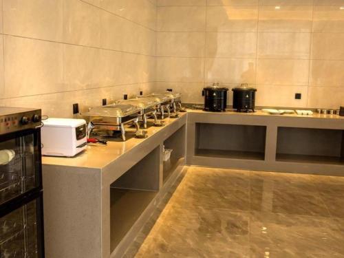 a kitchen with a counter with many pots and pans at GreenTree Inn Express Chuzhou Langya District Government Chuhe Road in Chuzhou