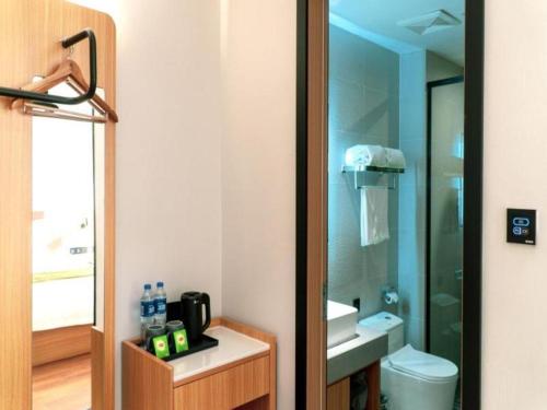 W łazience znajduje się umywalka, toaleta i lustro. w obiekcie GreenTree Inn Express Datong High-Speed Railway Station Old City Wall w mieście Datong