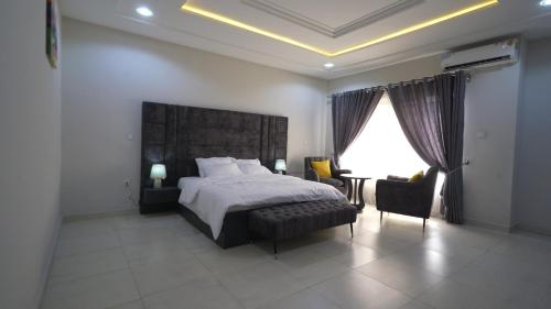 Schlafzimmer mit einem Bett, einem Tisch und Stühlen in der Unterkunft Kris Apartment in Ibadan