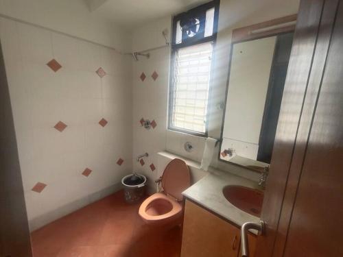 een badkamer met een roze toilet en een wastafel bij Individual Home 4 BR at Sector 7 HSR Layout in Bangalore