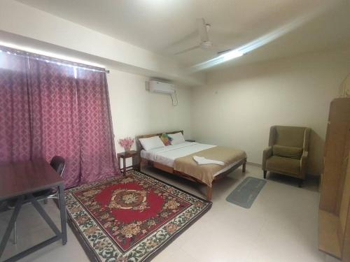een slaapkamer met een bed, een stoel en een tafel bij Individual Home 4 BR at Sector 7 HSR Layout in Bangalore