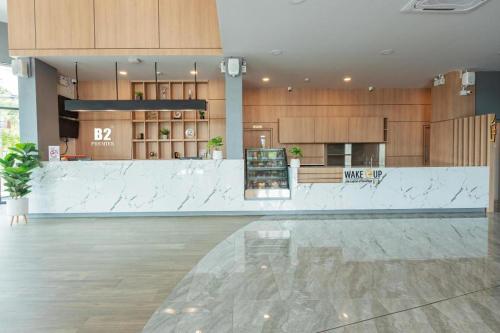 a large lobby with a counter in a building at B2 Surat Thani Premier Hotel in Surat Thani