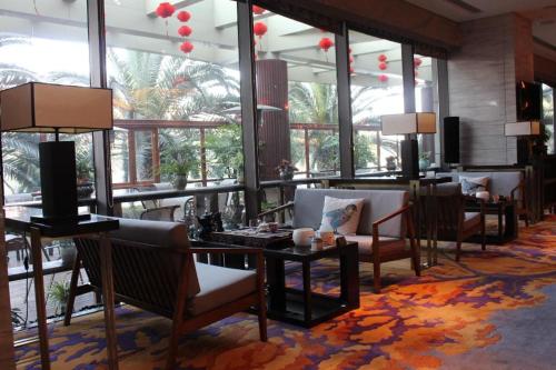 a lobby with tables and chairs and large windows at Balan International Hotel in Dujiangyan