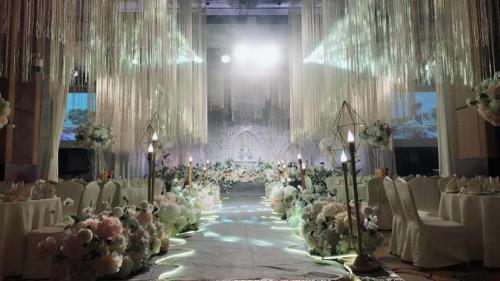a banquet hall with white tables and chairs and flowers at Balan International Hotel in Dujiangyan