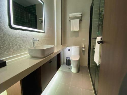 y baño con lavabo, aseo y espejo. en GreenTree Inn Express Datong High-Speed Railway Station Wanda Plaza Fangte en Shaling