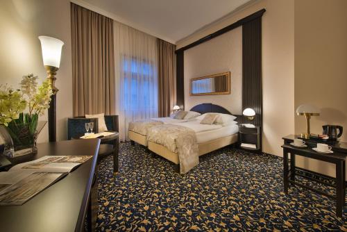 um quarto de hotel com uma cama e uma secretária em Hotel Esprit em Praga