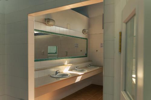 baño con 2 lavabos y espejo grande en Kampaoh El Rocío, en El Rocío