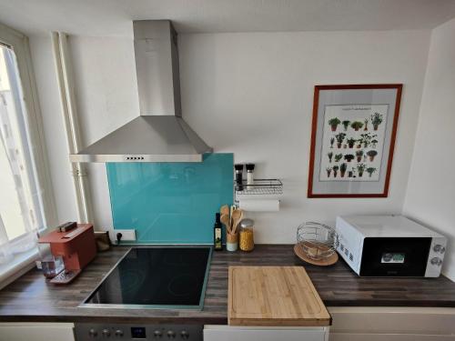 a kitchen with a counter with a sink and a microwave at 2 bedroom Apartment at Bahnhofcity in Feldkirch
