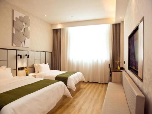 ein Hotelzimmer mit 2 Betten und einem großen Fenster in der Unterkunft GreenTree Inn Xinjiang Kashgar Food Street in Kashgar